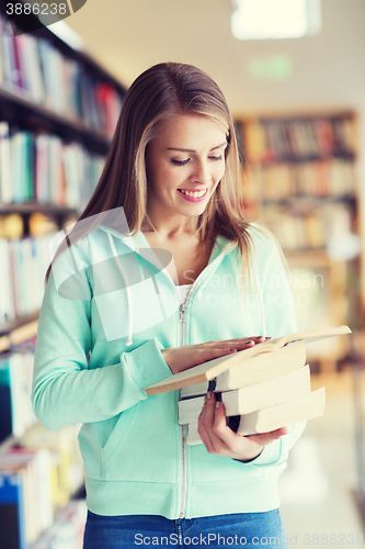 Image of happy student girl or woman with book in library