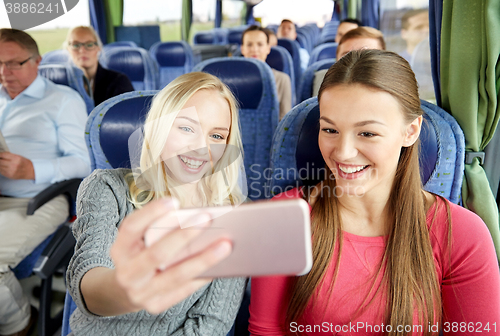 Image of women taking selfie by smartphone in travel bus