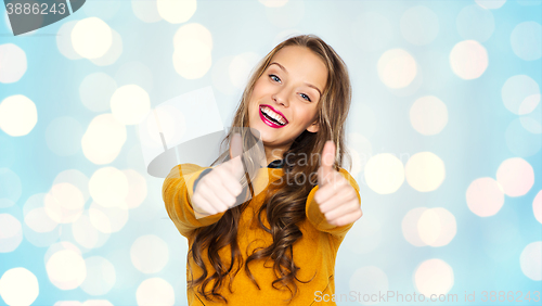 Image of happy young woman or teen girl showing thumbs up