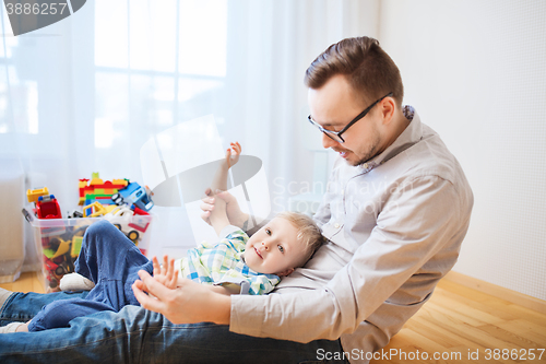 Image of father with son playing and having fun at home