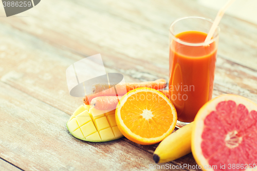 Image of close up of fresh juice glass and fruits on table