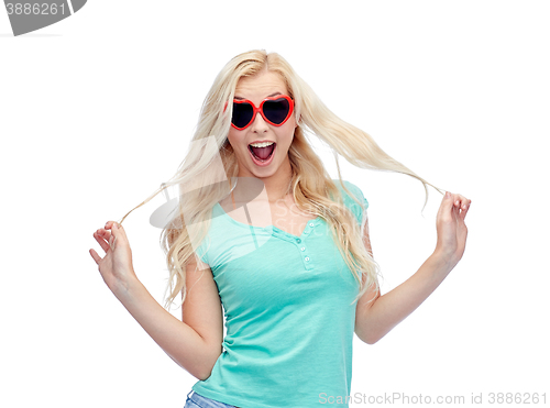 Image of happy young woman in heart shape sunglasses