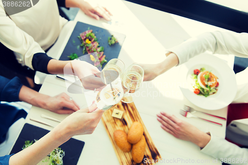 Image of close up of women clinking champagne at restaurant