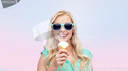 Image of happy young woman in sunglasses eating ice cream