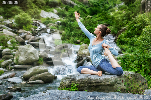 Image of Sorty fit woman doing yoga asana outdoors