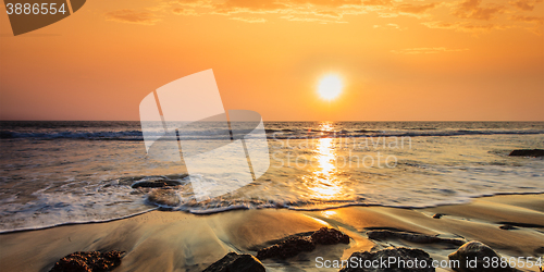 Image of Waves and rocks on beach of sunset