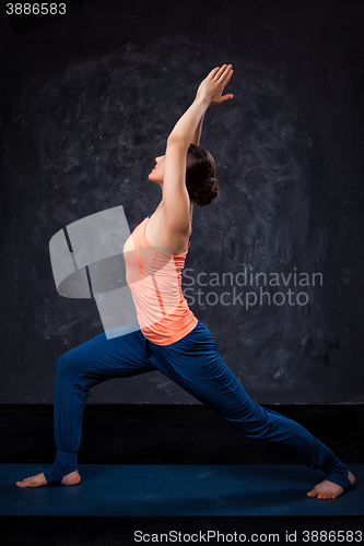 Image of Woman practices yoga asana utthita Virabhadras