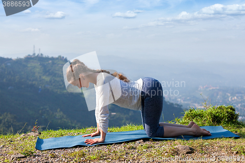 Image of Sporty fit woman practices yoga asana bitilasana 