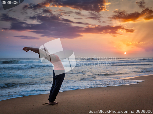 Image of Young sporty fit woman doing yoga Surya Namaskar