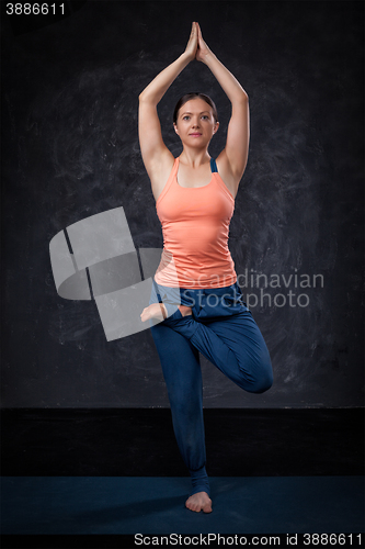 Image of Woman practices yoga asana Vrikshasana tree po