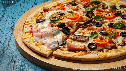 Image of Ham pizza on blue wooden background