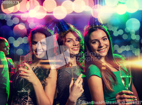 Image of smiling friends with glasses of champagne in club