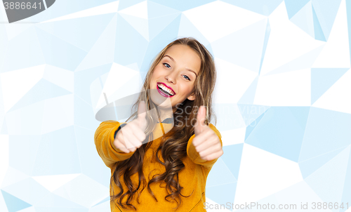 Image of happy young woman or teen girl showing thumbs up