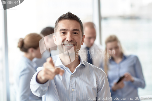 Image of group of smiling businesspeople meeting in office