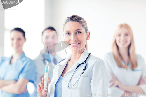 Image of female doctor holding syringe with injection