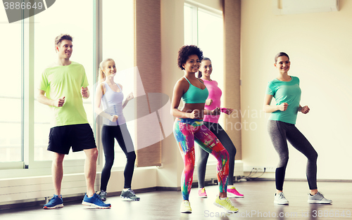 Image of group of smiling people dancing in gym or studio