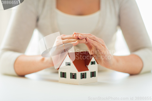 Image of close up of hands protecting house or home model