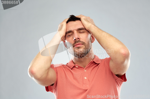 Image of unhappy man suffering from head ache