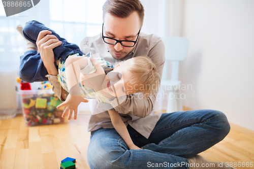 Image of father and son playing and having fun at home