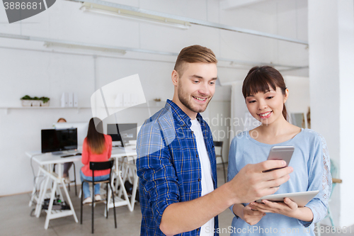 Image of couple with smartphone and tablet pc at office