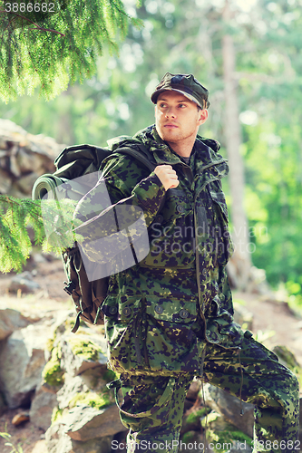 Image of young soldier with backpack in forest