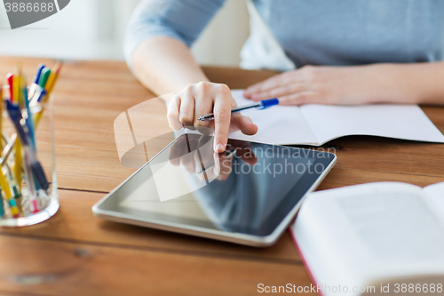 Image of close up of student with tablet pc and notebook