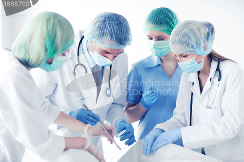 Image of young group of doctors doing operation