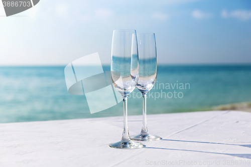 Image of  close up of two champagne glasses on beach 