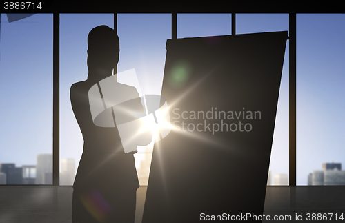 Image of silhouette of woman with flipboard over office