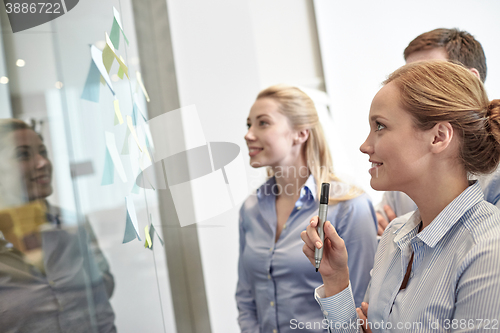 Image of smiling business people with marker and stickers