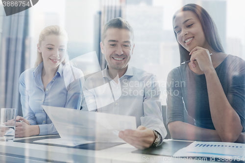 Image of group of smiling businesspeople meeting in office
