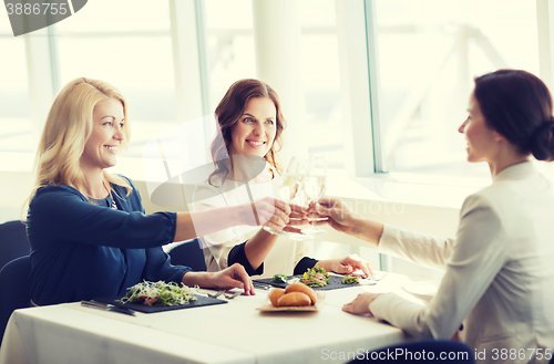 Image of happy women drinking champagne at restaurant