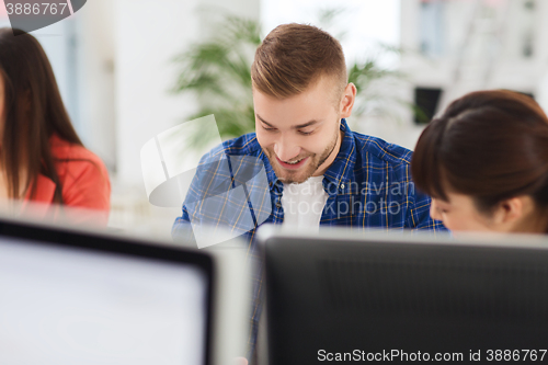 Image of happy creative team or students working at office
