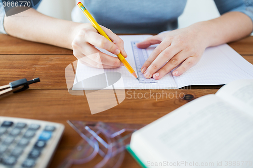 Image of close up of hands with ruler and pencil drawing 