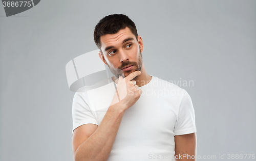 Image of man thinking over gray background