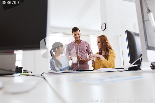 Image of happy creative team drinking coffee at office