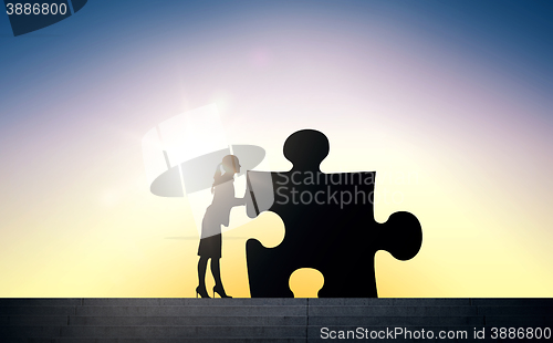 Image of silhouette of woman moving puzzle over sun light
