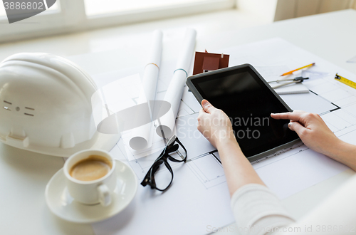 Image of close up of hand with blueprint and tablet pc