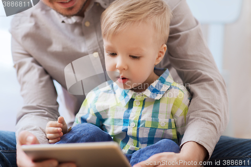 Image of father and son with tablet pc playing at home