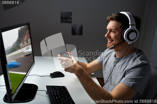 Image of man in headset playing computer video game at home