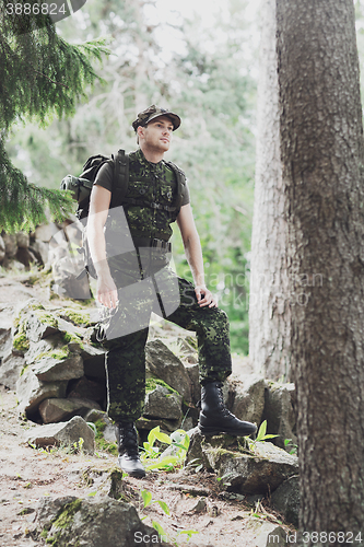 Image of young soldier with backpack in forest