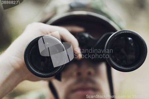 Image of close up of soldier or hunter with binocular