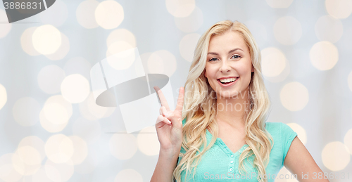 Image of smiling young woman or teenage girl showing peace