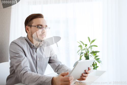 Image of creative male worker with tablet pc at home office