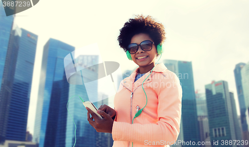 Image of happy young woman with smartphone and headphones