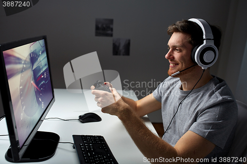 Image of man in headset playing computer video game at home