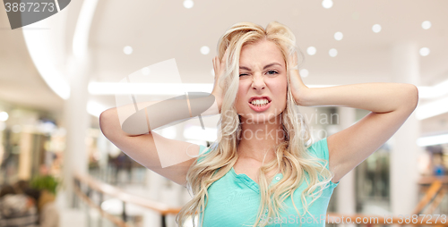 Image of young woman holding to her head and screaming