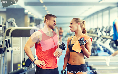 Image of smiling man and woman talking in gym
