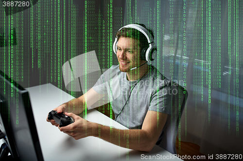 Image of man in headset playing computer video game at home