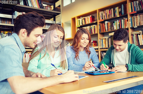 Image of happy students with tablet pc in library